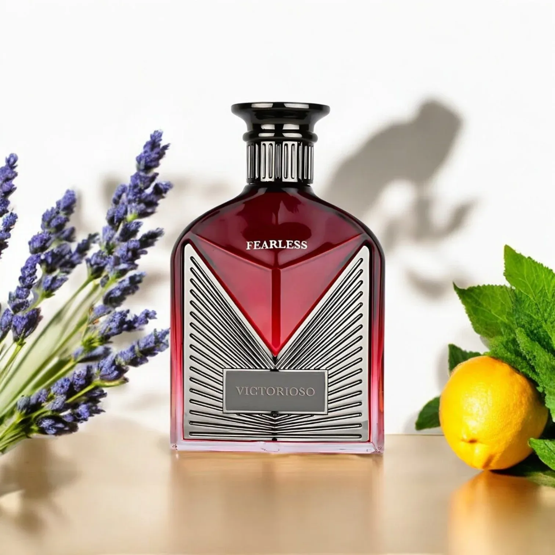 Maison Alhambra Victorioso Fearless by Maison Alhambra 100ml EDP — A red glass perfume bottle with a silver geometric design and a black cap, placed next to its white and red patterned box with the brand logo. | Maison Alhambra Victorioso Fearless by Maison Alhambra 100ml EDP — Botol kaca merah dengan reka bentuk