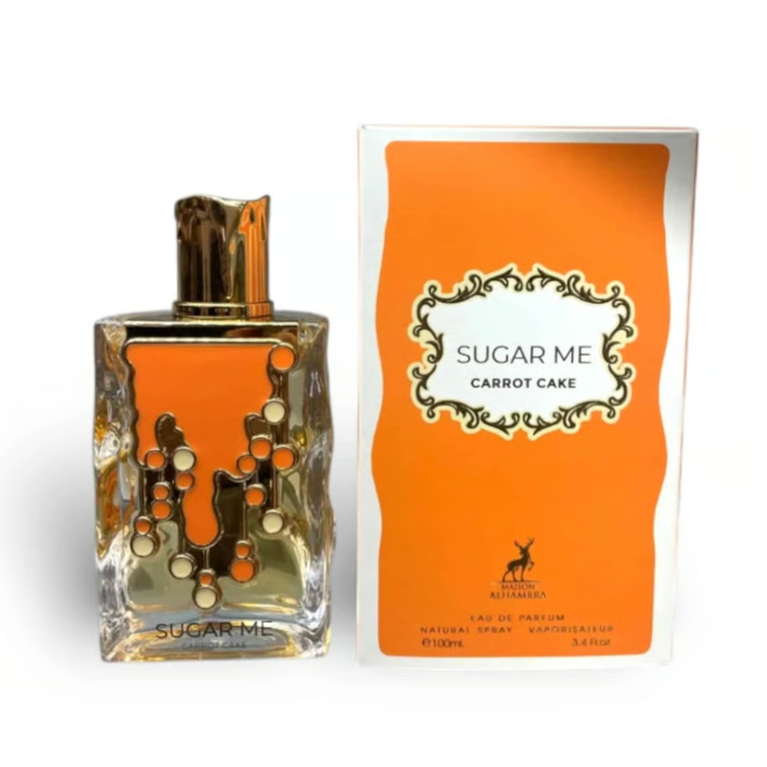 Maison Alhambra Sugar Me Carrot Cake — A clear glass perfume bottle with an orange liquid and gold decorative elements, next to its orange and white striped box with a gold ornate frame containing the product name. | Maison Alhambra Sugar Me Carrot Cake — Botol minyak wangi kaca jernih dengan cecair oren dan elemen
