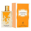 Maison Alhambra Sugar Me Carrot Cake — A clear glass perfume bottle with an orange liquid and gold decorative elements, next to its orange and white striped box with a gold ornate frame containing the product name. | Maison Alhambra Sugar Me Carrot Cake — Botol minyak wangi kaca jernih dengan cecair oren dan elemen