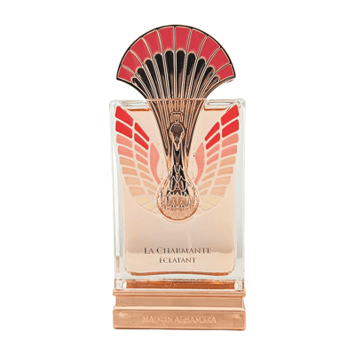 Maison Alhambra La Charmante Eclatant by Maison Alhambra 100ml EDP — A perfume bottle with a decorative fan-like gold and red atomizer sits next to its matching red and gold patterned box. | Maison Alhambra La Charmante Eclatant by Maison Alhambra 100ml EDP — Botol minyak wangi dengan penyembur emas dan merah seperti