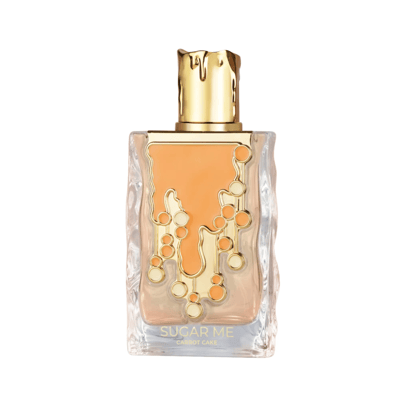 Maison Alhambra Sugar Me Carrot Cake — A clear glass perfume bottle with an orange liquid and gold decorative elements, next to its orange and white striped box with a gold ornate frame containing the product name. | Maison Alhambra Sugar Me Carrot Cake — Botol minyak wangi kaca jernih dengan cecair oren dan elemen