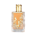 Maison Alhambra Sugar Me Carrot Cake — A clear glass perfume bottle with an orange liquid and gold decorative elements, next to its orange and white striped box with a gold ornate frame containing the product name. | Maison Alhambra Sugar Me Carrot Cake — Botol minyak wangi kaca jernih dengan cecair oren dan elemen