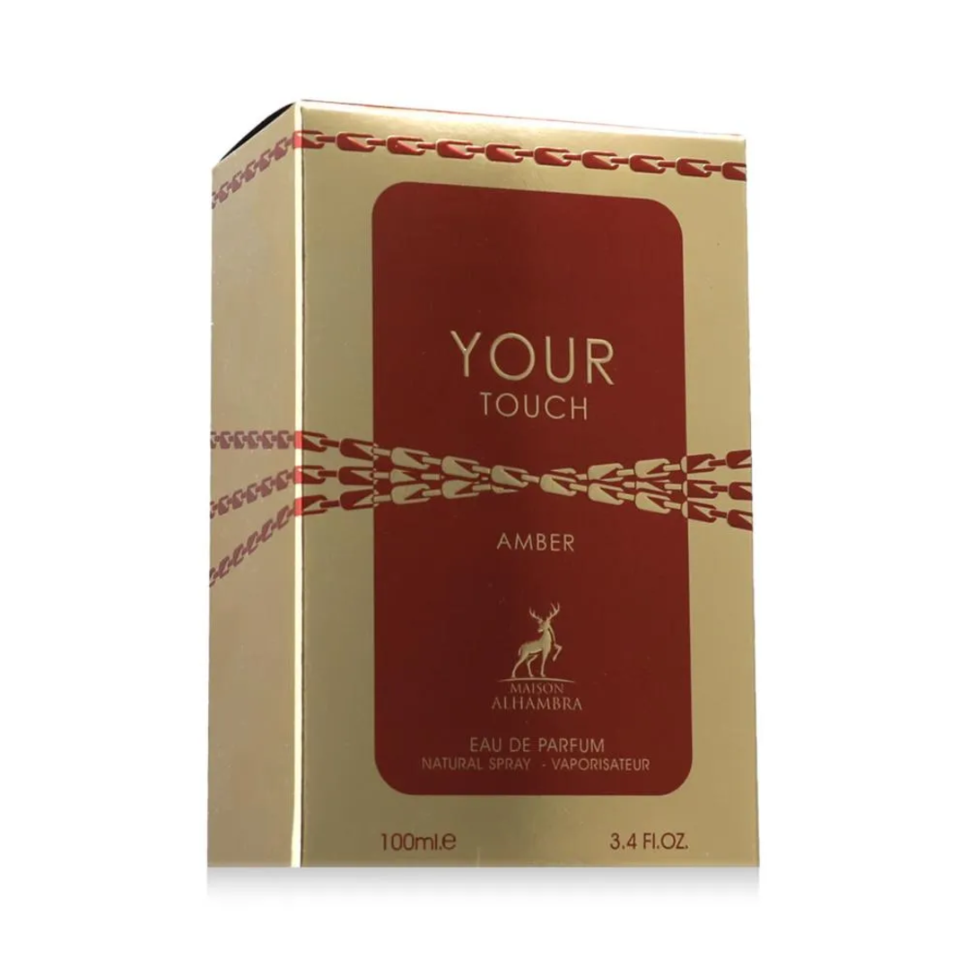 Maison Alhambra Your Touch Amber by Maison Alhambra 100ml — A rectangular amber glass perfume bottle with a gold ribbed cap sits next to its matching gold and orange box, which features a zipper-like design. | Maison Alhambra Your Touch Amber by Maison Alhambra 100ml — Botol kaca amber berbentuk segi empat dengan