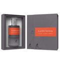 Maison Alhambra In Perfect Harmony 60ml EDP — A grey box and a grey perfume bottle with an orange label featuring the text 'in perfect harmony' are shown against a white background. | Maison Alhambra In Perfect Harmony 60ml EDP — Kotak kelabu dan botol minyak wangi kelabu dengan label oren bertulis 'in perfect