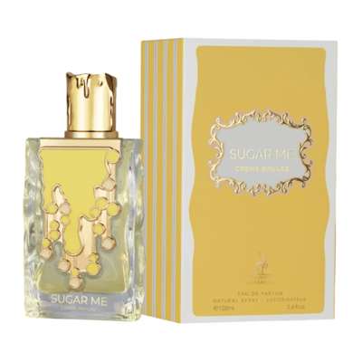 Maison Alhambra Sugar Me Creme Brulee — A clear glass perfume bottle with a gold cap and a yellow and gold decorative front, next to its yellow and white striped box with a decorative gold frame containing the product name. | Maison Alhambra Sugar Me Creme Brulee — Botol minyak wangi kaca jernih dengan penutup emas