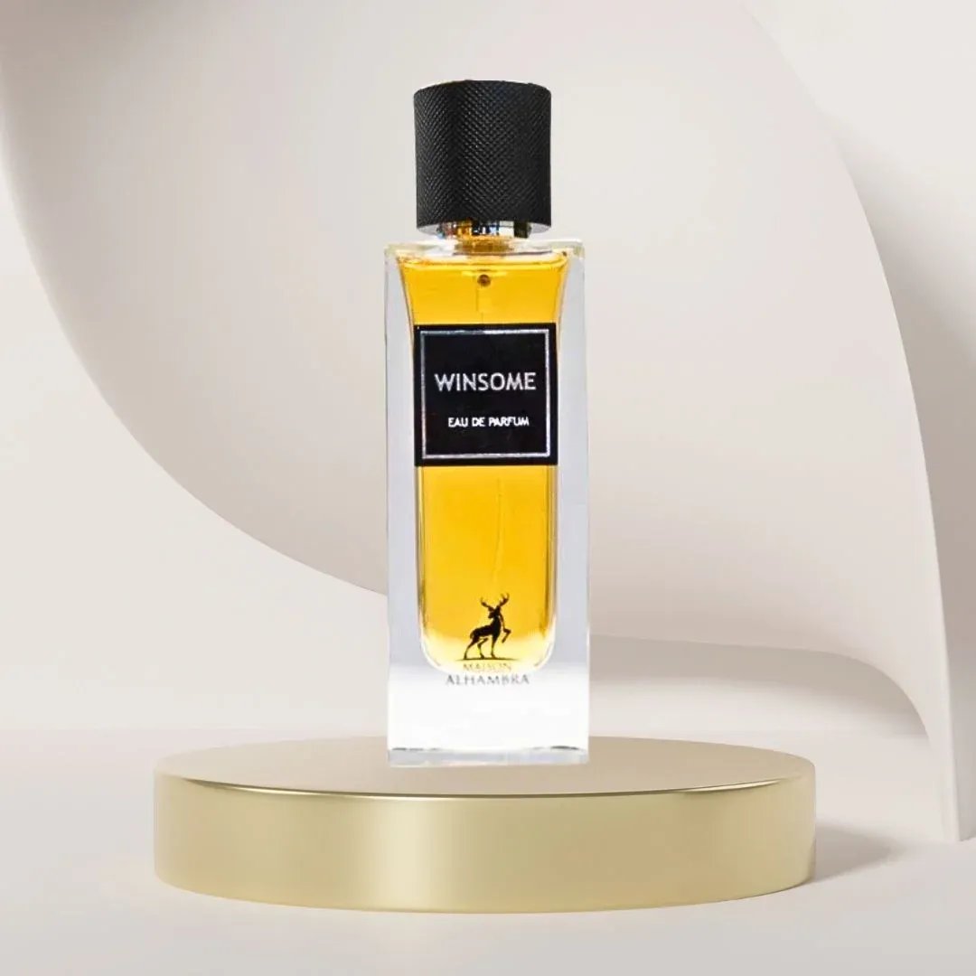 Maison Alhambra Winsome by Maison Alhambra 90ml EDP — A white box with black text and a deer logo sits next to a clear glass perfume bottle with yellow liquid and a black cap, displayed on a black and white tiered stand. | Maison Alhambra Winsome by Maison Alhambra 90ml EDP — Kotak putih dengan teks hitam dan logo