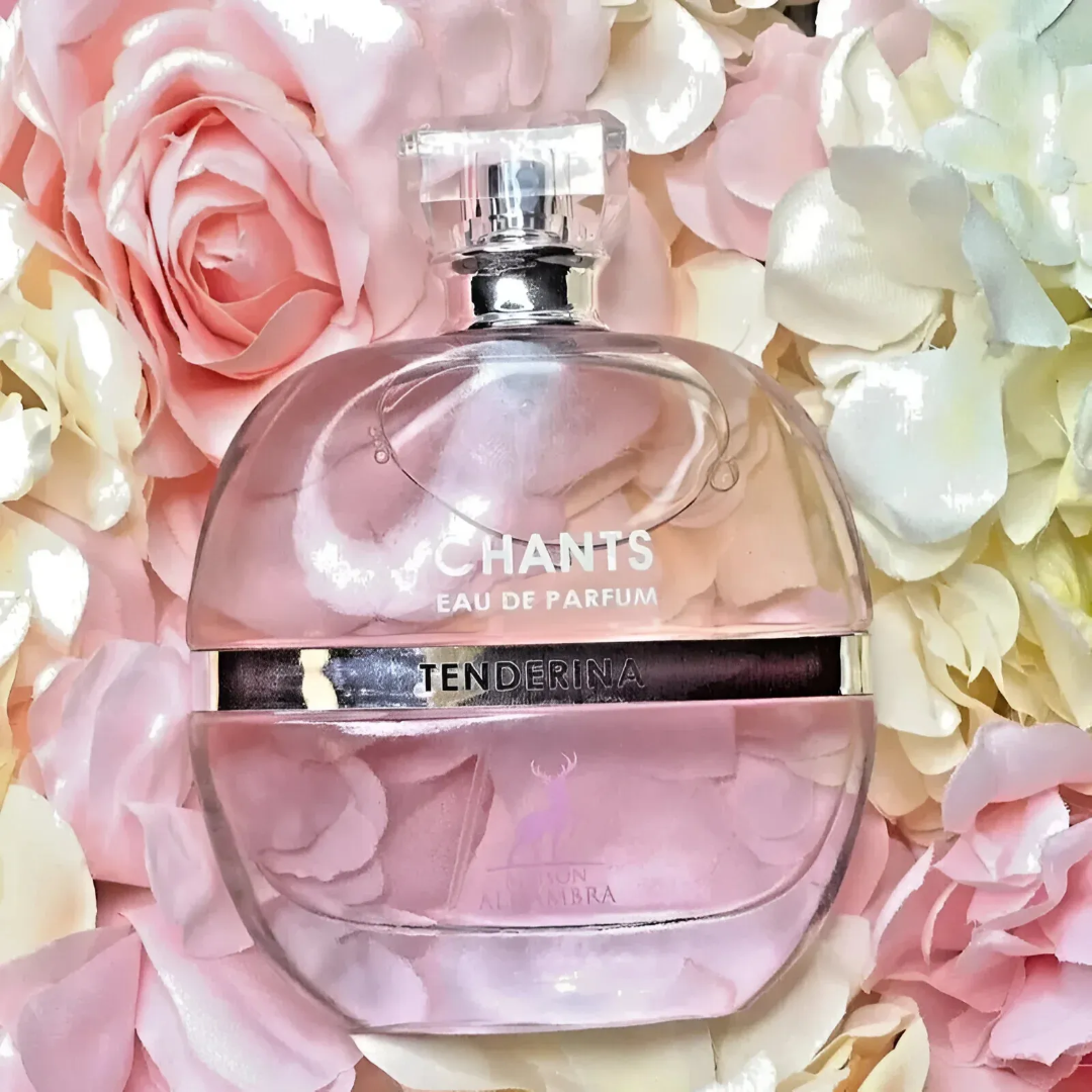 Maison Alhambra Chants Tenderina by Maison Alhambra 100ml EDP — A clear glass perfume bottle with a faceted cap sits next to its pink and white box, both featuring a deer logo and text. | Maison Alhambra Chants Tenderina by Maison Alhambra 100ml EDP — Botol minyak wangi kaca jernih dengan penutup berfacets terletak di
