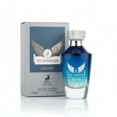 Maison Alhambra Victorioso Legend — A blue gradient glass perfume bottle with a silver textured cap stands next to its grey and blue box, both featuring a winged deer emblem. | Maison Alhambra Victorioso Legend — Botol minyak wangi kaca gradien biru dengan penutup bertekstur perak berdiri di sebelah kotak kelabu dan