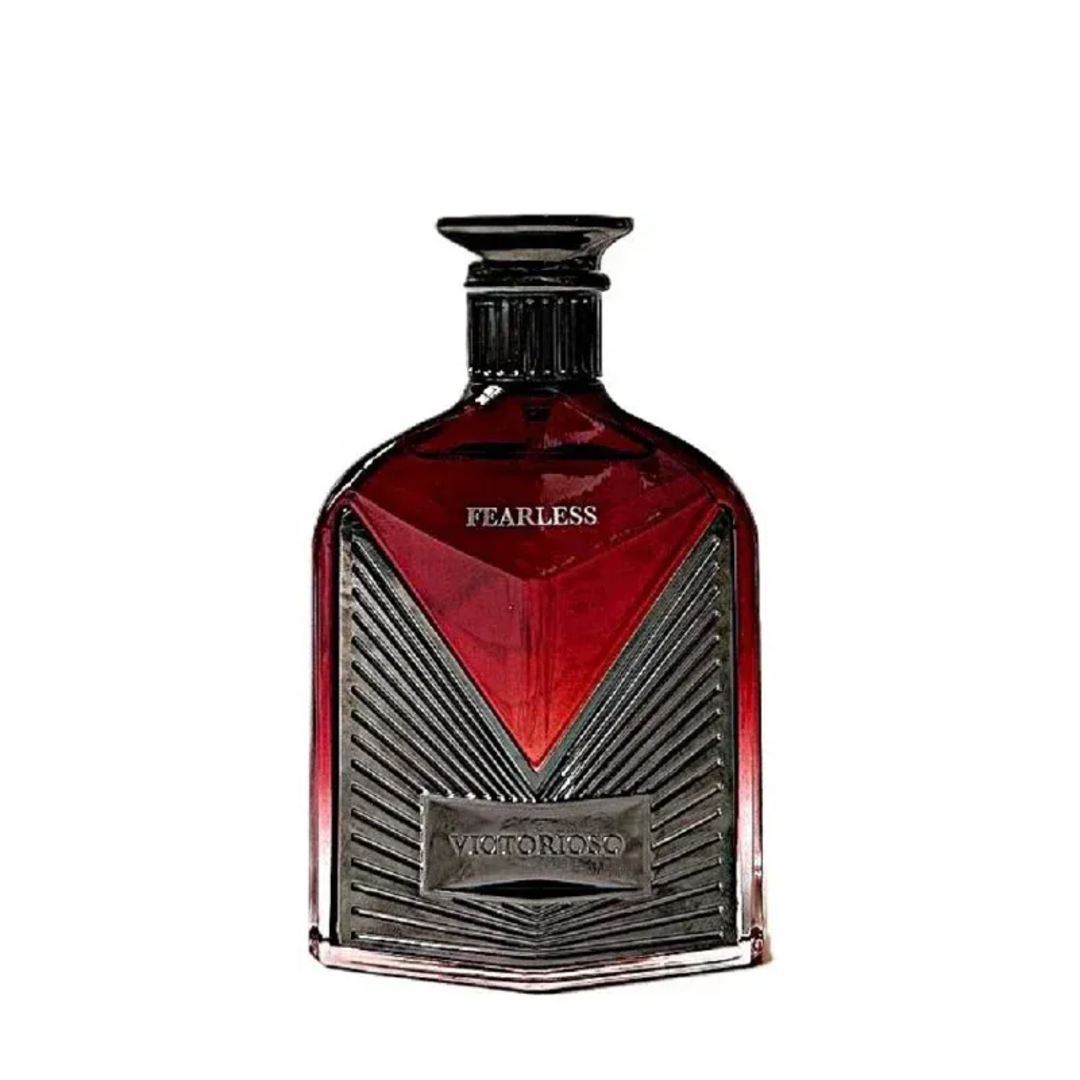 Maison Alhambra Victorioso Fearless by Maison Alhambra 100ml EDP — A red glass perfume bottle with a silver geometric design and a black cap, placed next to its white and red patterned box with the brand logo. | Maison Alhambra Victorioso Fearless by Maison Alhambra 100ml EDP — Botol kaca merah dengan reka bentuk