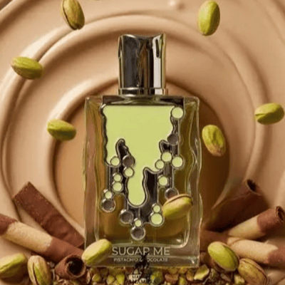 Maison Alhambra Sugar Me Pistachio Chocolate by Maison Alhambra 100ml EDP — A light green perfume bottle with a decorative, dripping design and dark accents, next to its matching light green box with ornate framing and text. | Maison Alhambra Sugar Me Pistachio Chocolate by Maison Alhambra 100ml EDP — Botol minyak
