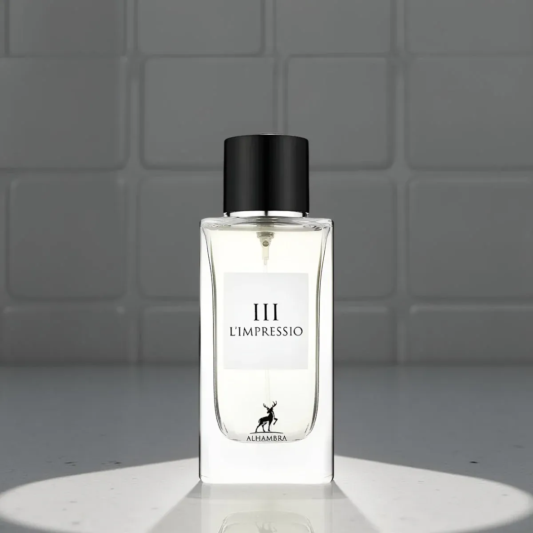 Maison Alhambra L'Impressio Pour Femme — White perfume box and clear glass bottle with black cap, featuring a deer logo and text. | Kotak pewangi putih dan botol kaca jernih bertutup hitam, menampilkan logo rusa dan teks.