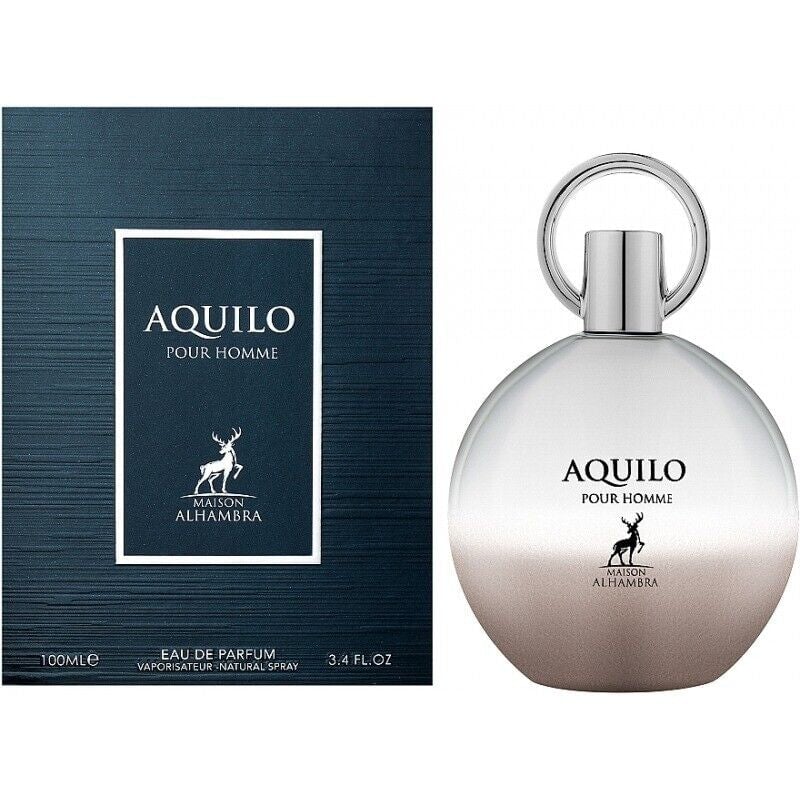 Maison Alhambra Aquilo Pour Homme — A dark blue textured box is shown next to a round, silver and gradient brown perfume bottle with a silver ring cap. | Maison Alhambra Aquilo Pour Homme — Kotak biru gelap bertekstur ditunjukkan di sebelah botol minyak wangi bulat, perak dan coklat gradien dengan penutup cincin perak.