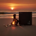 Maison Alhambra Luxe Street — A black perfume bottle with a geometric design and glowing orange light inside, shattered glass pieces scattered around it on a sandy beach at sunset with waves in the background. | Maison Alhambra Luxe Street — Botol minyak wangi hitam dengan reka bentuk geometri dan cahaya oren bersinar
