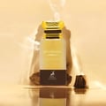 Maison Alhambra Mysterious Amber — A brown box and a clear glass bottle with a gold cap, both featuring the product name and brand logo. | Maison Alhambra Mysterious Amber — Kotak coklat dan botol kaca jernih dengan penutup emas, kedua-duanya memaparkan nama produk dan logo jenama.