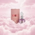 Maison Alhambra Candid by Maison Alhambra 100 ml for Women — A pink cylindrical box and a purple glass perfume bottle with a crystal-like cap sit amongst soft pink clouds. | Maison Alhambra Candid by Maison Alhambra 100 ml for Women — Kotak silinder merah jambu dan botol minyak wangi kaca ungu dengan penutup seperti