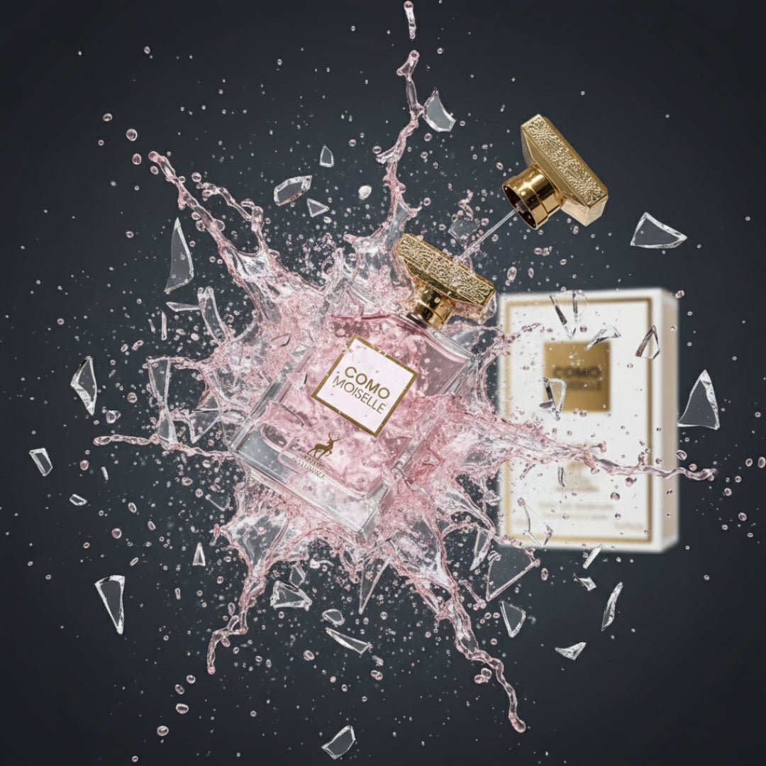 Maison Alhambra Como Moiselle by Maison Alhambra 100ml for Her — A perfume bottle exploding with pink liquid and glass shards against a dark background. A separate box is visible. | Maison Alhambra Como Moiselle by Maison Alhambra 100ml for Her — Botol minyak wangi meletup dengan cecair merah jambu dan serpihan kaca