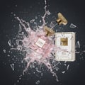 Maison Alhambra Como Moiselle by Maison Alhambra 100ml for Her — A perfume bottle exploding with pink liquid and glass shards against a dark background. A separate box is visible. | Maison Alhambra Como Moiselle by Maison Alhambra 100ml for Her — Botol minyak wangi meletup dengan cecair merah jambu dan serpihan kaca