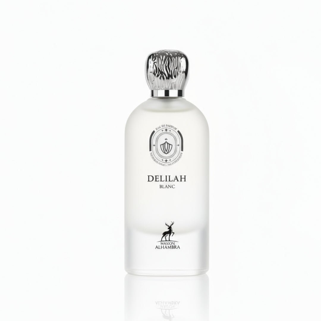 Maison Alhambra Delilah Blanc by Maison Alhambra 100ml EDP — A white frosted glass perfume bottle with a silver patterned cap, featuring a circular emblem and a deer silhouette on the lower half. | Maison Alhambra Delilah Blanc by Maison Alhambra 100ml EDP — Botol kaca putih beku dengan penutup berona perak bermotif