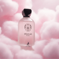 Maison Alhambra Delilah Blanc — A frosted pink glass perfume bottle with a black cap, set against a soft, fluffy pink cotton candy-like background. The label features a crest and the text "DELILAH BLANC" and a deer logo. | Maison Alhambra Delilah Blanc — Botol kaca merah jambu beku dengan penutup hitam, diletakkan di