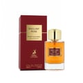 Maison Alhambra Exclusif Rose Maison Alhambra 100ml EDP — A maroon box with a gold square label sits next to a clear glass perfume bottle with an amber liquid and a gold cap. | Maison Alhambra Exclusif Rose Maison Alhambra 100ml EDP — Kotak merah maroon dengan label petak emas duduk bersebelahan botol minyak wangi