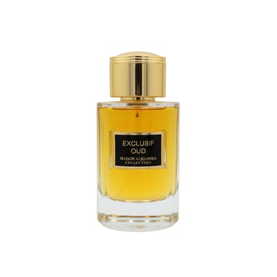 Maison Alhambra Exclusif Oud — A clear glass perfume bottle with golden cap and a black label reading "EXCLUSIF OUD MAISON ALHAMBRA COLLECTION". The liquid inside is amber-colored. | Botol minyak wangi kaca jernih dengan penutup emas dan label hitam bertuliskan "EXCLUSIF OUD MAISON ALHAMBRA COLLECTION". Cecair di