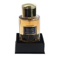 Maison Alhambra Exclusif Saffron – Amber liquid in a clear glass bottle with a gold cap, presented on a black square stand. | Maison Alhambra Exclusif Saffron – Cecair keemasan dalam botol kaca jernih bertutup emas, diletakkan di atas tapak segi empat hitam.