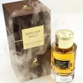 Maison Alhambra Exclusif Tabac – A perfume bottle with golden cap and amber liquid sits next to its brown, smoky-patterned box with a gold label. | Maison Alhambra Exclusif Tabac – Sebotol minyak wangi bertutup emas dan cecair berwarna ambar diletakkan di sebelah kotak coklatnya yang bercorak asap dengan label emas.