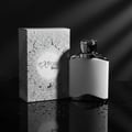 Maison Alhambra Expose Blanc by Maison Alhambra 100ml EDP Men — A black and white studio shot of a white perfume bottle and its patterned box, both reflecting on a wet, dark surface. | Maison Alhambra Expose Blanc by Maison Alhambra 100ml EDP Men — Rakaman studio hitam putih sebotol minyak wangi putih dan kotaknya