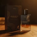 Maison Alhambra Exquisite Prive — A dark brown perfume box and a matching glass bottle with a black cap are displayed on a wooden surface with soft lighting. | Maison Alhambra Exquisite Prive — Peti minyak wangi berwarna coklat gelap dan botol kaca yang sepadan dengan penutup hitam dipamerkan di atas permukaan kayu