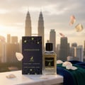 Maison Alhambra Extravagant Lover – A bottle of Extravagant Lover perfume and its box are displayed on a marble surface with rose petals scattered around. The Petronas Twin Towers are visible in the blurred background. | Maison Alhambra Extravagant Lover – Sebotol minyak wangi Extravagant Lover dan kotaknya dipamerkan