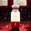 Maison Alhambra Forbidden Love — A clear and red glass perfume bottle with a silver and red cap, set against a dark, sparkling red background. | Maison Alhambra Forbidden Love — Botol kaca jernih dan merah dengan penutup perak dan merah, diletakkan di atas latar belakang merah gelap yang berkilauan.