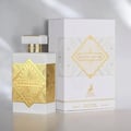 Maison Alhambra Infini Musk — White perfume bottle with gold geometric accents and a matching white and gold box, displayed on a neutral background. | Maison Alhambra Infini Musk — Botol minyak wangi putih dengan aksen geometri emas dan kotak putih dan emas yang sepadan, dipaparkan pada latar belakang neutral.