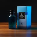 Maison Alhambra Jean Lowe Azure — Blue glass perfume bottle and matching blue box with wave design, set on a wooden surface with dark background. | Maison Alhambra Jean Lowe Azure — Botol minyak wangi kaca biru dan kotak biru sepadan dengan rekaan ombak, diletakkan di atas permukaan kayu dengan latar belakang gelap.