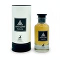 Maison Alhambra Jean Lowe Fraiche — A perfume bottle and its cylindrical packaging stand side-by-side against a white background. The bottle is clear glass with yellow liquid and a black cap. The packaging is white with a black label featuring text and a deer silhouette. | Botol minyak wangi dan pembungkus silindernya