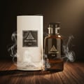 Maison Alhambra Jean Lowe Noir Maison Alhambra 100ml EDP — A dark glass perfume bottle and its cylindrical white box are displayed on a wooden surface, surrounded by wisps of smoke. | Maison Alhambra Jean Lowe Noir Maison Alhambra 100ml EDP — Botol kaca gelap dan kotak silindernya yang berwarna putih dipamerkan di