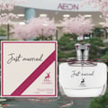Maison Alhambra Just Married by Maison Alhambra Woman 100ml — A perfume box and bottle are displayed in front of a blurred background of cherry blossoms and a building with the AEON logo. | Maison Alhambra Just Married by Maison Alhambra Woman 100ml — Sekotak dan sebotol minyak wangi dipamerkan di hadapan latar