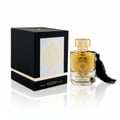 Maison Alhambra Karat by Maison Alhambra 100ml EDP — A black box with a gold ornate design on a white label sits next to a clear glass perfume bottle with gold accents and a black tassel. | Maison Alhambra Karat by Maison Alhambra 100ml EDP — Kotak hitam dengan rekaan perhiasan emas pada label putih terletak di