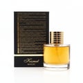 Maison Alhambra Kismet Magic by Maison Alhambra 100ml EDP Unisex — A clear glass perfume bottle with golden cap and yellow liquid sits next to its black and gold box, which has text in multiple languages. | Maison Alhambra Kismet Magic by Maison Alhambra 100ml EDP Unisex — Botol minyak wangi kaca jernih dengan penutup