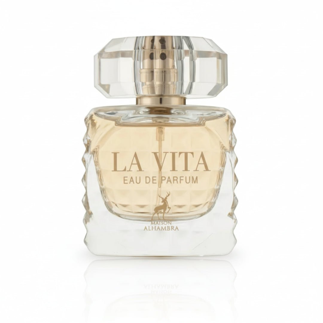 Maison Alhambra La Vita EDP — A clear glass perfume bottle with a faceted geometric design on the sides and a faceted clear cap. The liquid inside is pale yellow. A small deer silhouette is printed on the front. | Maison Alhambra La Vita EDP — Botol kaca jernih dengan rekaan geometri berfaset di sisi dan penutup