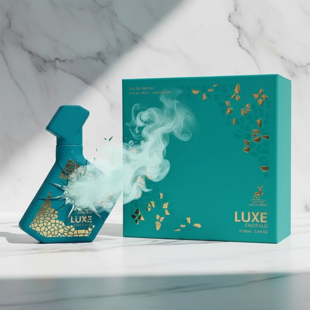 Maison Alhambra Luxe Emerald Perfume Maison Alhambra 100ml Unisex — Teal spray bottle with gold geometric pattern and smoke effect, next to its teal box with gold accents on a marble background. | Maison Alhambra Luxe Emerald Perfume Maison Alhambra 100ml Unisex — Botol semburan teal dengan corak geometri emas dan
