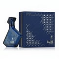 Maison Alhambra Luxe Journey – Blue geometric patterned perfume bottle next to a dark blue box with geometric pattern and text | Maison Alhambra Luxe Journey – Botol minyak wangi biru bercorak geometri di sebelah kotak biru gelap dengan corak geometri dan teks