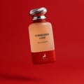 Maison Alhambra Forbidden Love — A frosted glass perfume bottle with a red base and a silver ribbed cap, set against a vibrant red background. | Botol minyak wangi kaca beku dengan tapak merah dan penutup berjalur perak, diletakkan di atas latar belakang merah terang.
