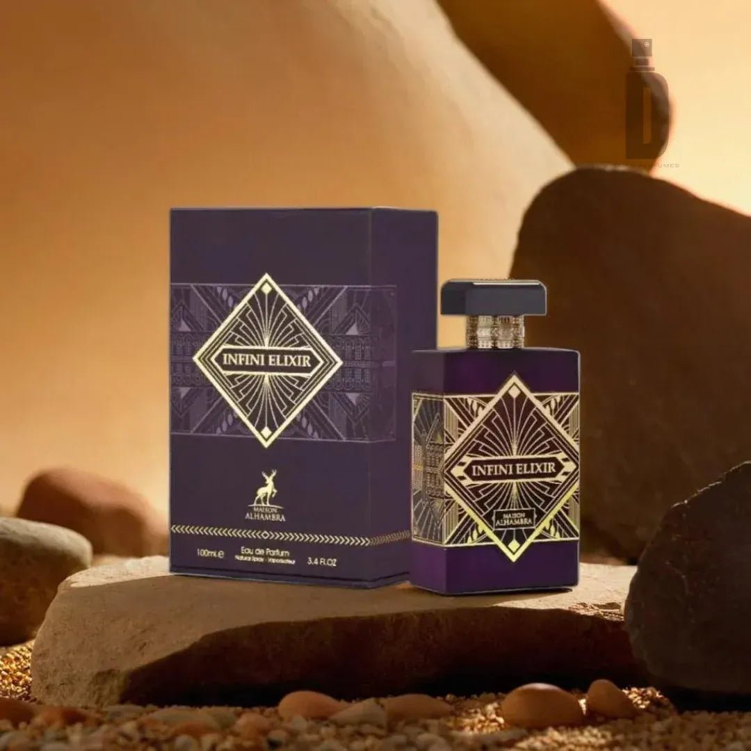 Maison Alhambra Infini Elixir — A purple perfume bottle and its box are displayed on a rocky surface with sand and pebbles, featuring gold geometric patterns. | Maison Alhambra Infini Elixir — Botol minyak wangi ungu dan kotaknya dipamerkan di permukaan berbatu dengan pasir dan kerikil, menampilkan corak geometri emas.