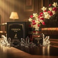 Maison Alhambra Versencia Noir – A black perfume box and bottle are surrounded by clear crystal shards, with red and white flower petals and glitter exploding upwards. | Maison Alhambra Versencia Noir – Kotak dan botol minyak wangi hitam dikelilingi serpihan kristal jernih, dengan kelopak bunga merah dan putih serta