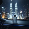 Maison Alhambra Maitre De Blue by Maison Alhambra 100ml for Men — A clear glass perfume bottle with a black cap sits on a car dashboard at night, with the illuminated Petronas Twin Towers in Kuala Lumpur visible in the background. | Maison Alhambra Maitre De Blue by Maison Alhambra 100ml for Men — Botol kaca jernih