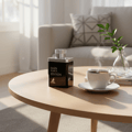 Maison Alhambra Man Black Edition Maison Alhambra 100ml EDP — Black perfume bottle on a wooden table next to a steaming cup of coffee and a small plant in a vase. | Botol minyak wangi hitam di atas meja kayu bersebelahan cawan kopi berasap dan pokok kecil dalam pasu.