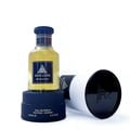 Jean Lowe Immortel by Maison Alhambra — A clear glass perfume bottle with a dark blue cap and label sits on a dark blue box, with a white cylindrical box lying on its side next to it. | Jean Lowe Immortel oleh Maison Alhambra — Botol minyak wangi kaca jernih dengan penutup dan label biru gelap diletakkan di atas kotak