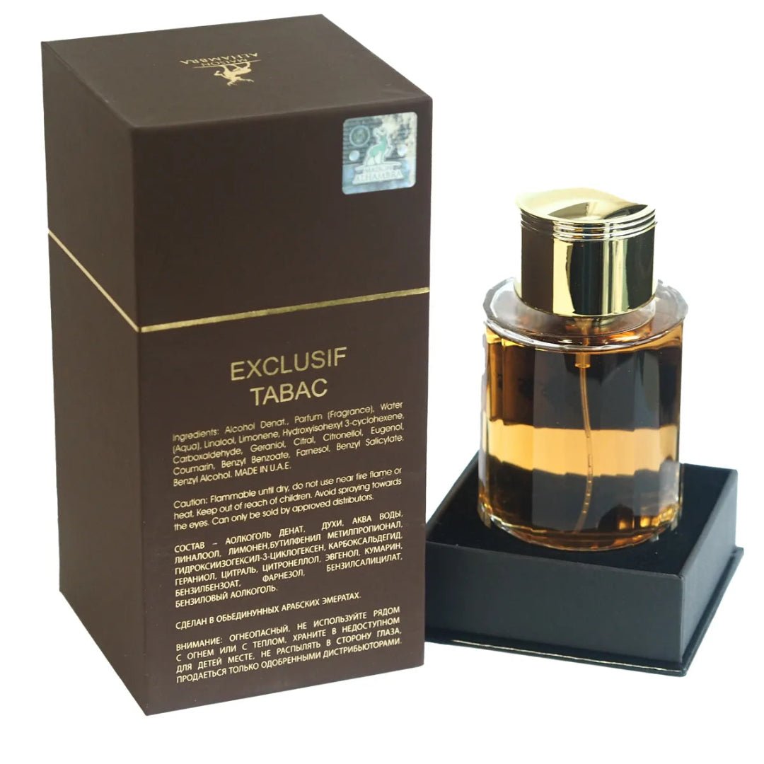 Maison Alhambra Exclusif Tabac by Maison Alhambra – 100 ml Unisex — A brown box with gold accents sits next to a clear glass perfume bottle with a gold cap, filled with amber liquid. The box has product information printed on it. | Maison Alhambra Exclusif Tabac by Maison Alhambra – 100 ml Unisex — Kotak coklat dengan