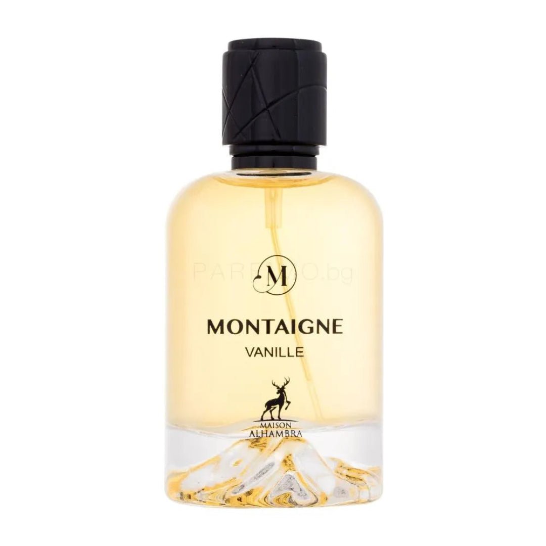 Maison Alhambra Montaigne Vanille — A clear glass perfume bottle with a black textured cap, golden liquid, and a decorative mountain landscape at the base, featuring a deer silhouette logo. | Maison Alhambra Montaigne Vanille — Botol minyak wangi kaca jernih dengan penutup bertekstur hitam, cecair keemasan, dan