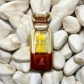 Maison Alhambra Mysterious Amber — A brown box and a clear glass bottle with a gold cap, both featuring the product name and brand logo. | Maison Alhambra Mysterious Amber — Kotak coklat dan botol kaca jernih dengan penutup emas, kedua-duanya memaparkan nama produk dan logo jenama.